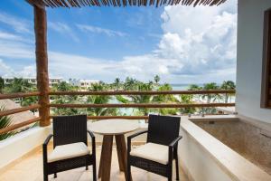 Un balcón con una mesa y dos sillas y el océano en Secrets Akumal Riviera Maya - Adults Only, en Akumal