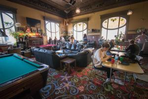 un groupe de personnes assises dans un bar avec un billard dans l'établissement Green Tortoise Hostel, à San Francisco