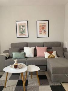 uma sala de estar com um sofá cinzento e uma mesa em La Florida em Ciudad Real
