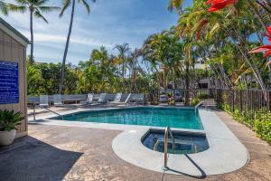 - une piscine avec des chaises longues et des palmiers dans l'établissement New! Kailua Bay Resort 2-306 - Beautifully renovated two-story condo with Primary Suite in Loft, à Kailua-Kona