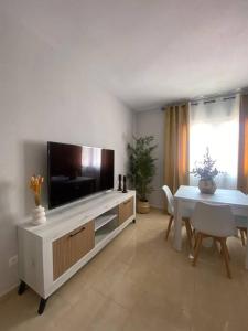 a living room with a flat screen tv and a table at La Florida in Ciudad Real