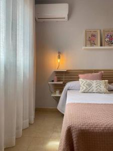 um quarto com uma cama e um candeeiro sobre uma mesa em La Florida em Ciudad Real