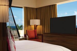a hotel room with a bed and a flat screen tv at Secrets Akumal Riviera Maya - Adults Only in Akumal