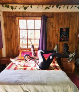 una chica acostada en una cama con sus piernas en el aire en Suite Refugio de Luz, en Chillán