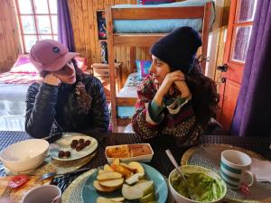 dos mujeres sentadas en una mesa con un plato de comida en Suite Refugio de Luz, en Chillán