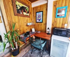 a room with a wooden desk with a computer at Suite Refugio de Luz in Chillán