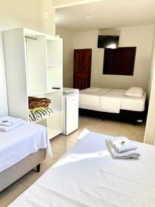 a hotel room with two beds and a room with two beds at Pousada Serra de São Thomé in São Thomé das Letras