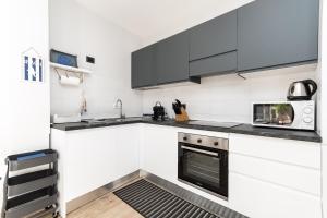 a kitchen with white cabinets and a microwave at Cozy Terrace in Portofino [Free Parking] in Portofino