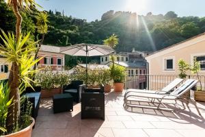 patio z krzesłami, parasolem i palmami w obiekcie Cozy Terrace in Portofino [Free Parking] w Protofino