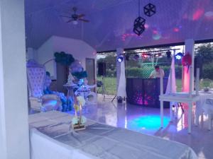 um quarto com uma mesa e uma festa com luzes roxas em Cabañas Villa Albita em Villavicencio