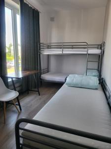 a room with two bunk beds and a desk at Rooms4Rest Wiertnicza - Private rooms for tourists - ATR Consulting Sp, z o,o, in Warsaw