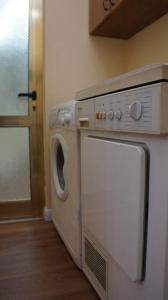 Una lavadora y secadora en una cocina junto a una puerta en Alle's Myslym Shyri studio apartment, en Tirana