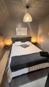 sypialnia z dużym łóżkiem i żyrandolem w obiekcie Gîte Libre’Air w mieście Redu
