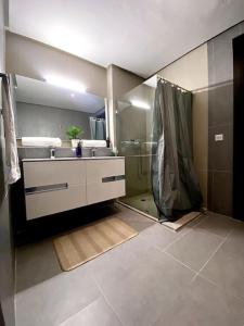 a bathroom with a shower and a sink at Luxurious Golf & Sea View Beach Apartment with Pool Access - Cocon de Taghazout Bay in Taghazout