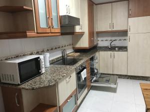 a kitchen with a sink and a microwave at Casa Nano in Sigüeiro