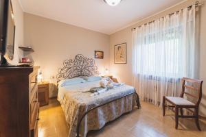 um quarto com uma cama, uma cadeira e uma janela em Casa Ambrogi relax in collina em Valfabbrica