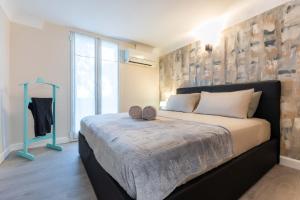 een slaapkamer met een groot bed en een groot raam bij MAISON SUR MER - Garage & Jardin Privè in Roquebrune-Cap-Martin