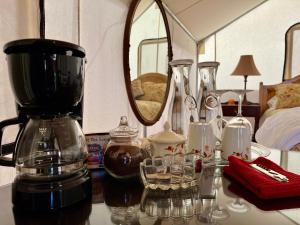 un tavolo con macchinetta del caffè e bicchieri di Cosmo Glamping Tent at Zenzen Gardens a Paonia
