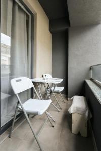 - deux tables et des chaises dans une chambre avec fenêtre dans l'établissement Porta Apartment, à Skopje