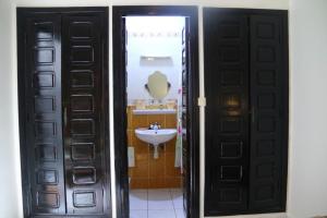 a bathroom with two black doors and a sink at Dar tabazariste in Marrakesh