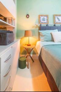 1 dormitorio con 1 cama y 1 mesa con lámpara en Loft, en Río de Janeiro