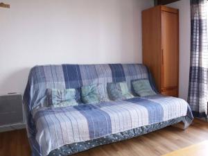 a bedroom with a bed with a blue plaid blanket at Appartement Les Orres, 1 pièce, 4 personnes - FR-1-322-390 in Les Orres