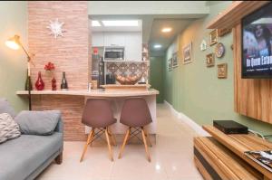 sala de estar con cocina y bar con 2 sillas en Loft, en Río de Janeiro