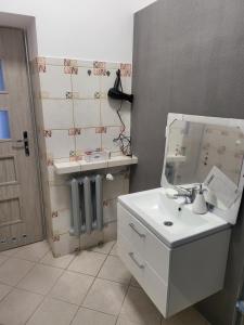 La salle de bains est pourvue d'un lavabo blanc et d'un miroir. dans l'établissement Rooms4Rest Wiertnicza - Private rooms for tourists - ATR Consulting Sp, z o,o,, à Varsovie