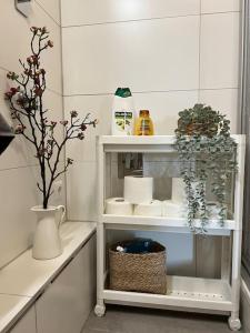 uma prateleira branca com um vaso e flores nele em “Sweet boho penthouse” in city center em Lahr