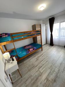 Cette chambre comprend 2 lits superposés et une table. dans l'établissement Luxurious apartment with 3 rooms and 2 bathrooms in Corabia, à Corabia