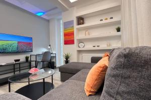 ein Wohnzimmer mit einem Sofa und einem Tisch in der Unterkunft FlatG 23 in Athen