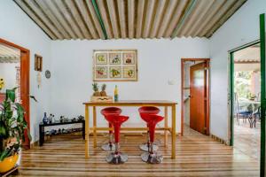 a dining room with a table and two red stools at Finca Umnisa - Choachi in Choachí