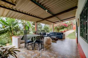 a patio with a table and chairs and a couch at Finca Umnisa - Choachi in Choachí