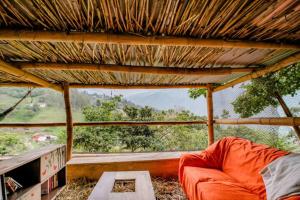 a couch sitting in a room with a large window at Finca Umnisa - Choachi in Choachí