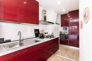 a kitchen with red cabinets and a sink at Portofino's Little Nest [Wi-Fi & A/C] in Portofino