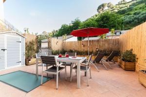 een patio met een tafel en stoelen en een parasol bij Portofino's Little Nest [Wi-Fi & A/C] in Portofino