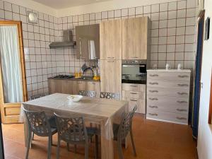 a kitchen with a table and chairs in a kitchen at Villa Mediterranean Sunset in Punta Braccetto