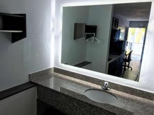 a bathroom with a sink and a mirror at Suburban Studios North Charleston I-526 in Charleston