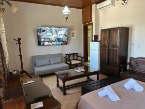 SeaFront Stone Suites في فونيتسا: غرفة معيشة بها سريرين وأريكة