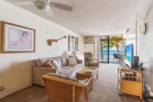 Una sala de estar con un sofá y un televisor. en New Top Hawaii Oceanfront 2BR/2BR with White Sand Beach-Kona Bali Kai 206, en Kailua-Kona