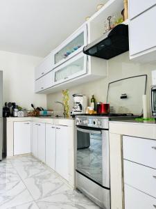 a kitchen with white cabinets and an oven at Le MARIE B&B in Cartagena de Indias