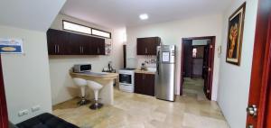 a small kitchen with a refrigerator and a sink at NCG Suite in Guayaquil