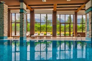 a swimming pool with lounge chairs and a pool house at The Nature View Suite, part of Terra Complex & Spa in Bansko