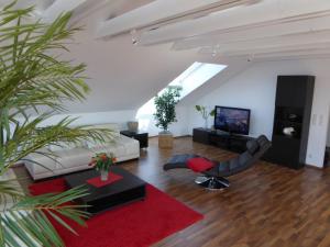 uma sala de estar com um sofá branco e um tapete vermelho em Ferienwohnung Bodenseeblick em Nonnenhorn
