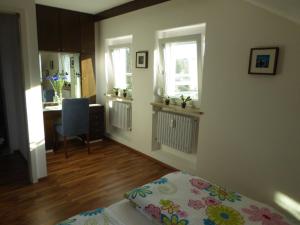ein Schlafzimmer mit einem Bett und eine Küche mit einem Schreibtisch in der Unterkunft Ferienwohnung Bodenseeblick in Nonnenhorn