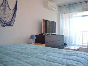 een slaapkamer met een bed, een dressoir en een televisie bij Appartement Banyuls-sur-Mer, 3 pièces, 6 personnes - FR-1-225C-57 in Banyuls-sur-Mer