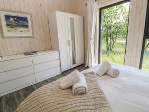 a bedroom with a bed with towels on it at Dragonfly Lodge in Bideford