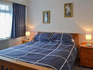 1 dormitorio con 1 cama con sábanas azules y 2 lámparas en Josies Den en Bridlington