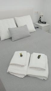 een slaapkamer met 2 bedden en witte handdoeken bij Apartamento a estrenar a 300 m de la playa de San Lorenzo en Gijón in Gijón