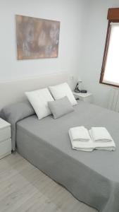 een slaapkamer met een bed met twee handdoeken erop bij Apartamento a estrenar a 300 m de la playa de San Lorenzo en Gijón in Gijón